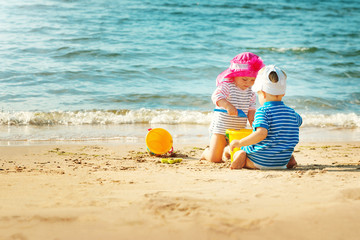 Wall Mural - Babygirl and babyboy sitting on the beach