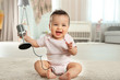 © Africa Studio - Cute little baby with microphone at home
