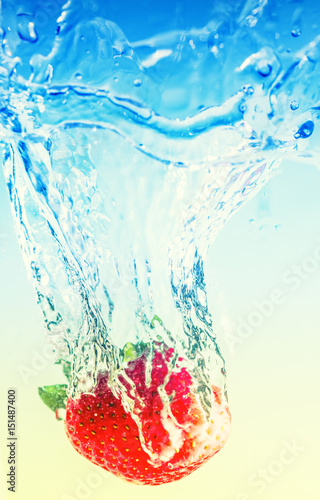 Obraz w ramie strawberry falling in water, leaving splashes and bubbles