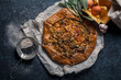 © Anastasiia Nurullina - French styled leek and onion galette with sage and gruyere cheese made with wholegrain flour. Textured blue background. Rustic concept with copy space