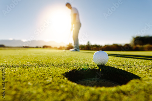 Obrazy golf  mezczyzna-kladzie-pilke-na-zielonym-polu-golfowym
