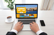 © DenPhoto - man sitting behind laptop with hotel booking screen in office