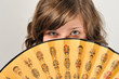 Junge Frau 20 Jahre hält einen mit Gold Farbe bedrucken chinesischen Fächer mit Holzgriff