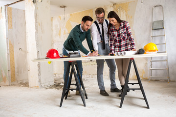 Wall Mural - Three  architects checking blueprint