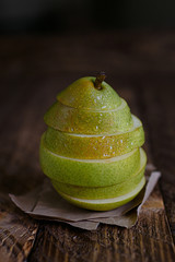 Pear in slices on wood background