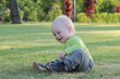 © ShapikMedia - A child is playing in the park on the grass.