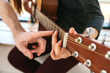 Wall Mural - Learning to play the guitar. Music education.