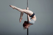 Young woman exercise pole dance gray background