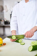 © pressmaster - Chef slicing fresh cucumber for salad