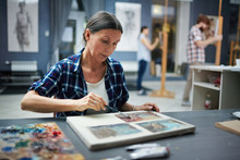 Portrait Of Mature Student Working In Art Studio Painting Pictures Looking Focused And Concentrated