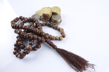 Wall Mural - Rosary and coins on white background. Islamic business concept.