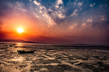 sunset, boat aground in low-tide