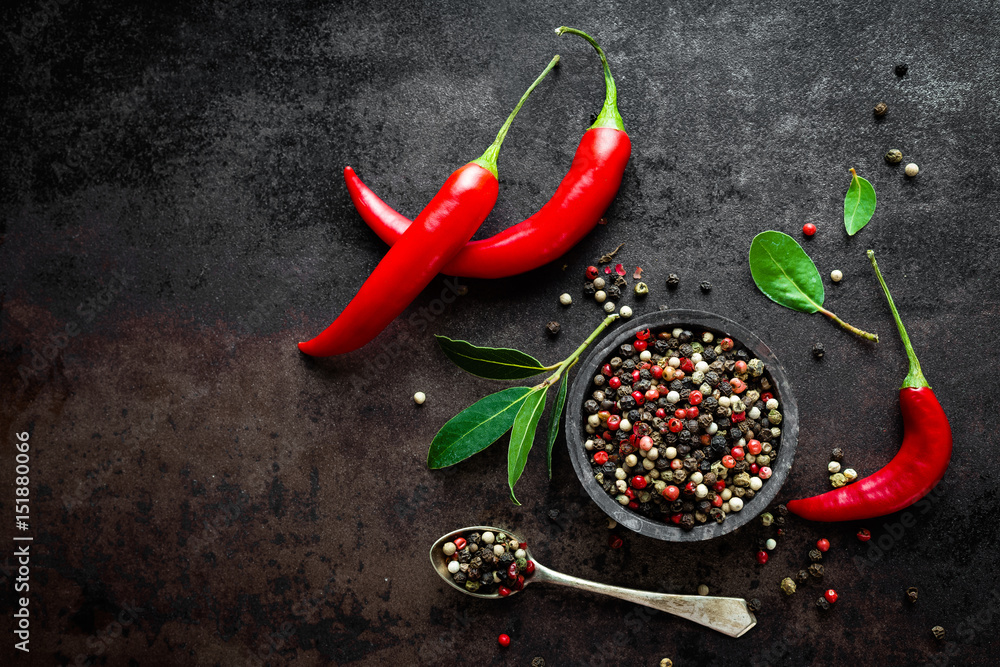 Red hot chili pepeprs and peppercorns on black metal background, top view - obrazy, fototapety, plakaty 