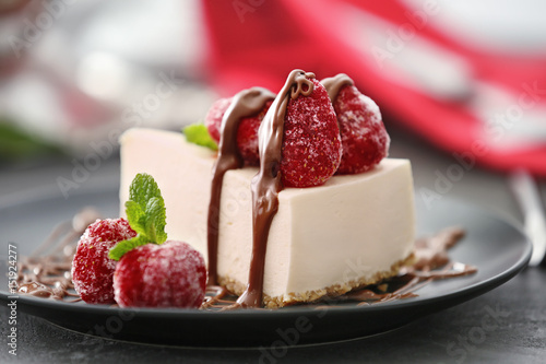 Fotografering  Tasty cheesecake slice with berries on plate