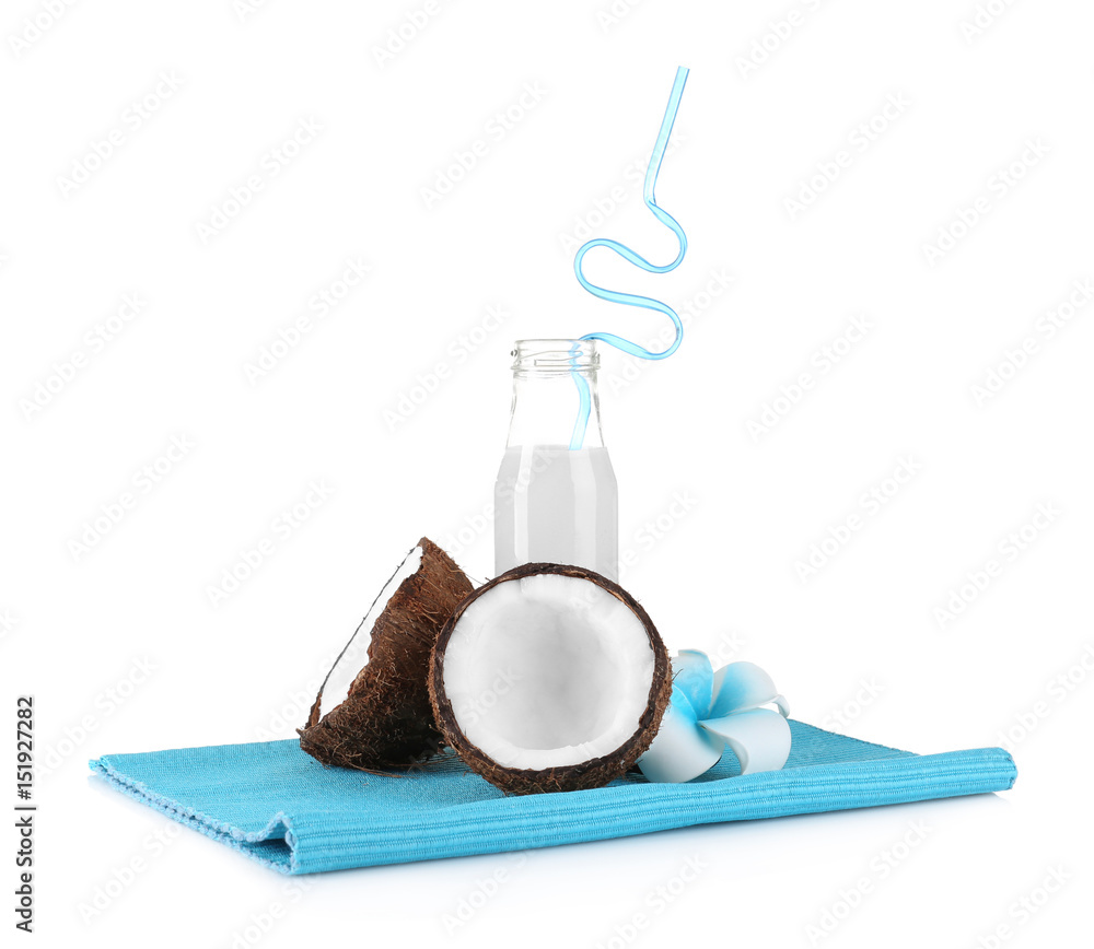 Bottle of coconut milk and fresh nut on white background