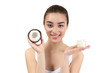 © Africa Studio - Beautiful young woman holding coconut oil and fresh nut on white background
