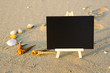 © NAWAWI - black board on sand beach .copy space area for concept