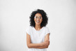 © wayhome.studio  - Indoor portrait of beautiful young dark-skinned woman wearing big round eyeglasses and casual white t-shirt smiling joyfully, keeping arms crossed, laughing out loud while watching comedy on TV