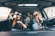 © F8  \ Suport Ukraine - Three beautiful young cheerful women looking at each other with smile while sitting in car