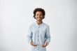 © wayhome.studio  - Handsome young African American male wearing light long shirt smiling and gesturing with both hands, having clueless expression on his face, standing at white wall with copy space for your text