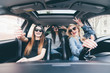 © F8  \ Suport Ukraine - Three beautiful young cheerful women making selfie and smiling while sitting in car together