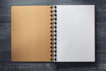 Poster - checked notebook at wooden  background