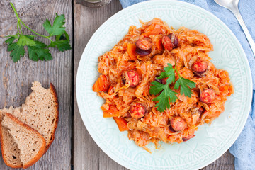 Wall Mural - Stewed cabbage with sausages, German cuisine, horizontal, top view