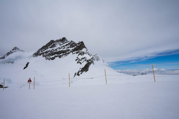 View from Jungfraujoch, Switzerland in the blue sky sunny day, Top of Europe, Fence and caution sign on the observation desk of Jungfrau