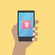 © vvadyab - Hand with cart icon on mobile phone vector illustration, Hand hold smart phone screen with shopping application