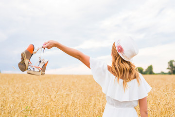 Young woman holding a shoe - sale, consumerism and people concept