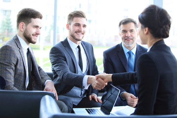 Wall Mural - Business people shaking hands, finishing up a meeting.