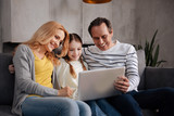 Fototapeta Tulipany - Positive family using electronic gadget at home