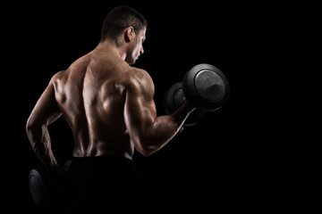 Athletic man training biceps on black background