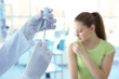 © Africa Studio - Hands of doctor preparing for vaccination and blurred patient on background