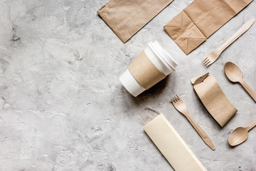 food delivery with paper bags and plastic cup on stone table background top view mockup