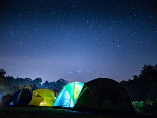 night mountain landscape with illuminated tent