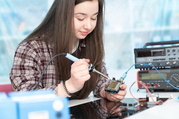 Wall Mural - The girl adjusts the electronics  system on the microprocessor