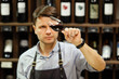 © Ilshat - Bokal of red wine on background, male sommelier appreciating drink