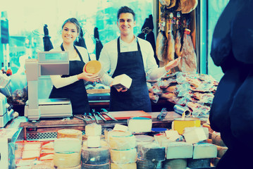 Wall Mural - Two workers selling cheese and sausages