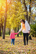 © Avatar_023 - Mother and daughter walking through the autumn park.Lens flare.Focus on the daughter face