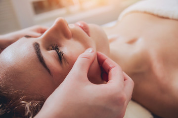 Beautiful woman in spa salon getting facial massage