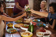 © Monkey Business - Host and friends making a toast at a dinner party, close up