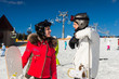 © kolotype - Young smiling couple in ski suits, helmets and ski goggles standing with snowboards in a ski resort