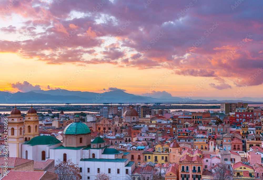 Sunset on Cagliari, evening panorama of the old city center in Sardinia Capital, view on The Old Cathedral and colored houses in traditional style, Italy - obrazy, fototapety, plakaty 