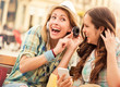 © bobex73 - Listening to music. Two girls have fun with mobile phone. Lifestyle, fashion, technology
