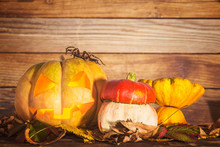 Pumpkin With Autumn Leaves On The Wooden Background