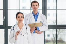 Portrait Of Two Determined Physicians Looking At Camera In A Modern Health Center