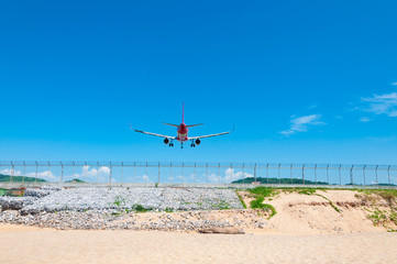 Two jet engine airplane landing on runway back view in Phuket international airport nearby the beach, Thailand