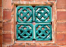 A Red Brick Wall And Asian Style Latticework Window.