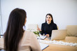 © F8  \ Suport Ukraine - Two business woman sitting at desk: customer and adviser talking together in modern office